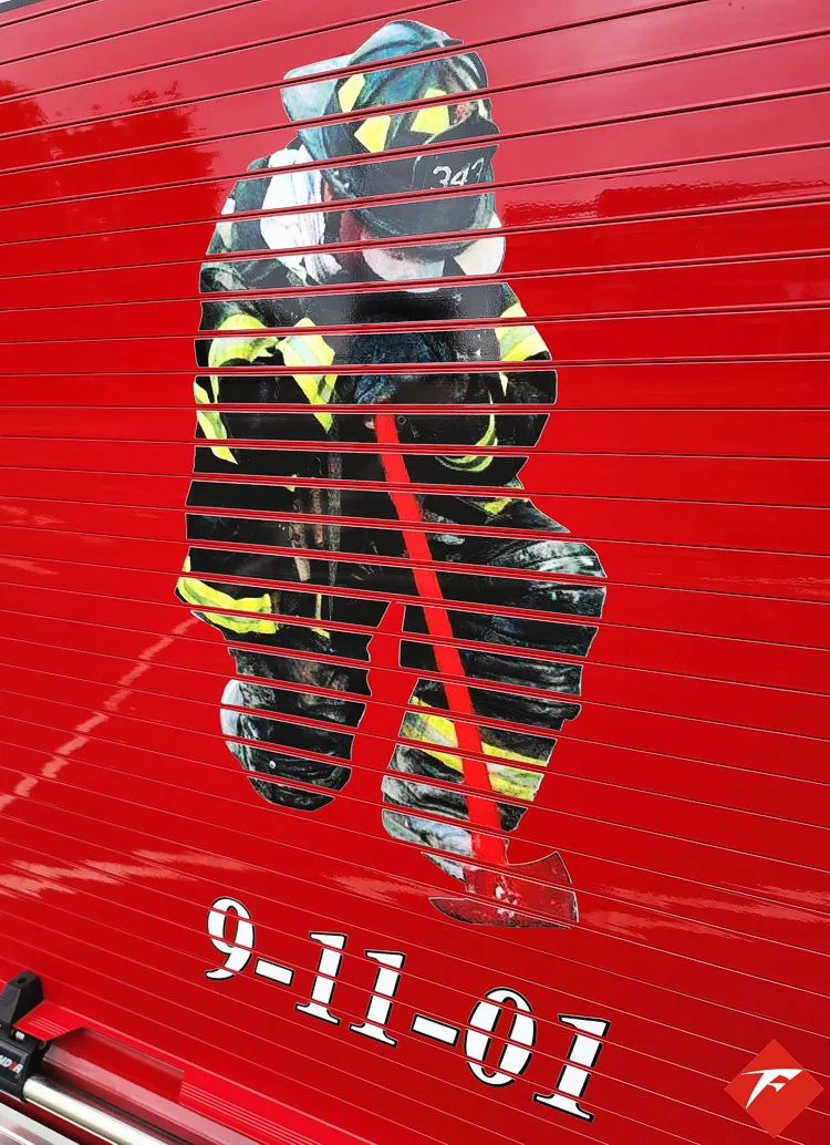 Body panel close-up showing memorial-style firefighter graphic on red roll-up door