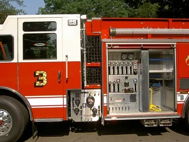 Pump panel close-up showing gauges, valves, and open side compartment