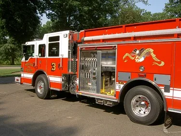 Driver-side rear three-quarter view showing open pump panel and rear wheel area