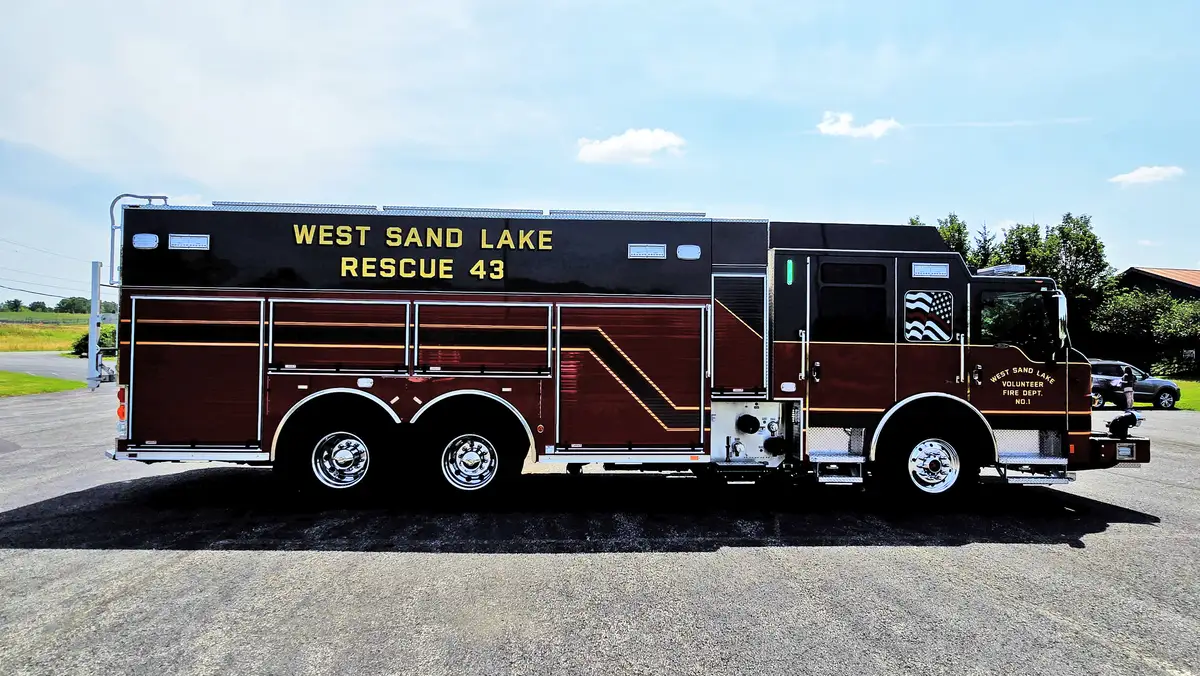 Driver-side full profile showing tandem rear wheels and long compartment line