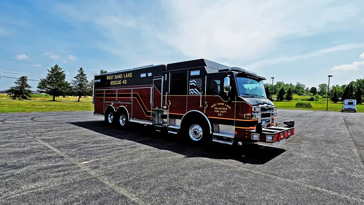 Driver-side three-quarter view showing cab, side compartments, and wheel area