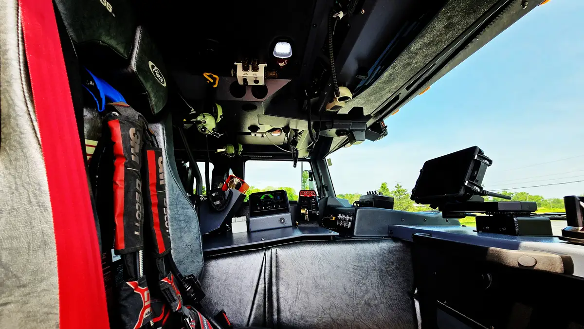 Cab interior wide view showing center console, front seats, and windshield