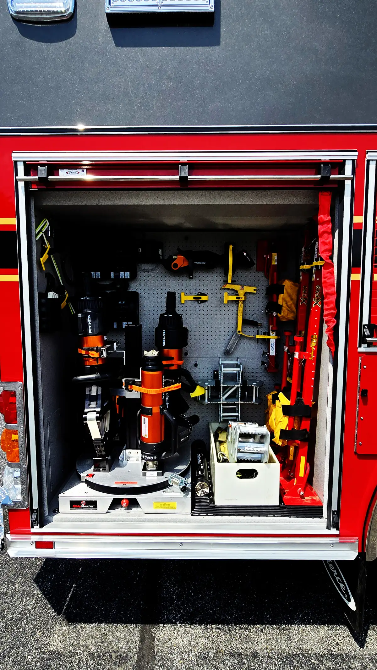 Open side compartment showing mounted hydraulic rescue tools and hand tools