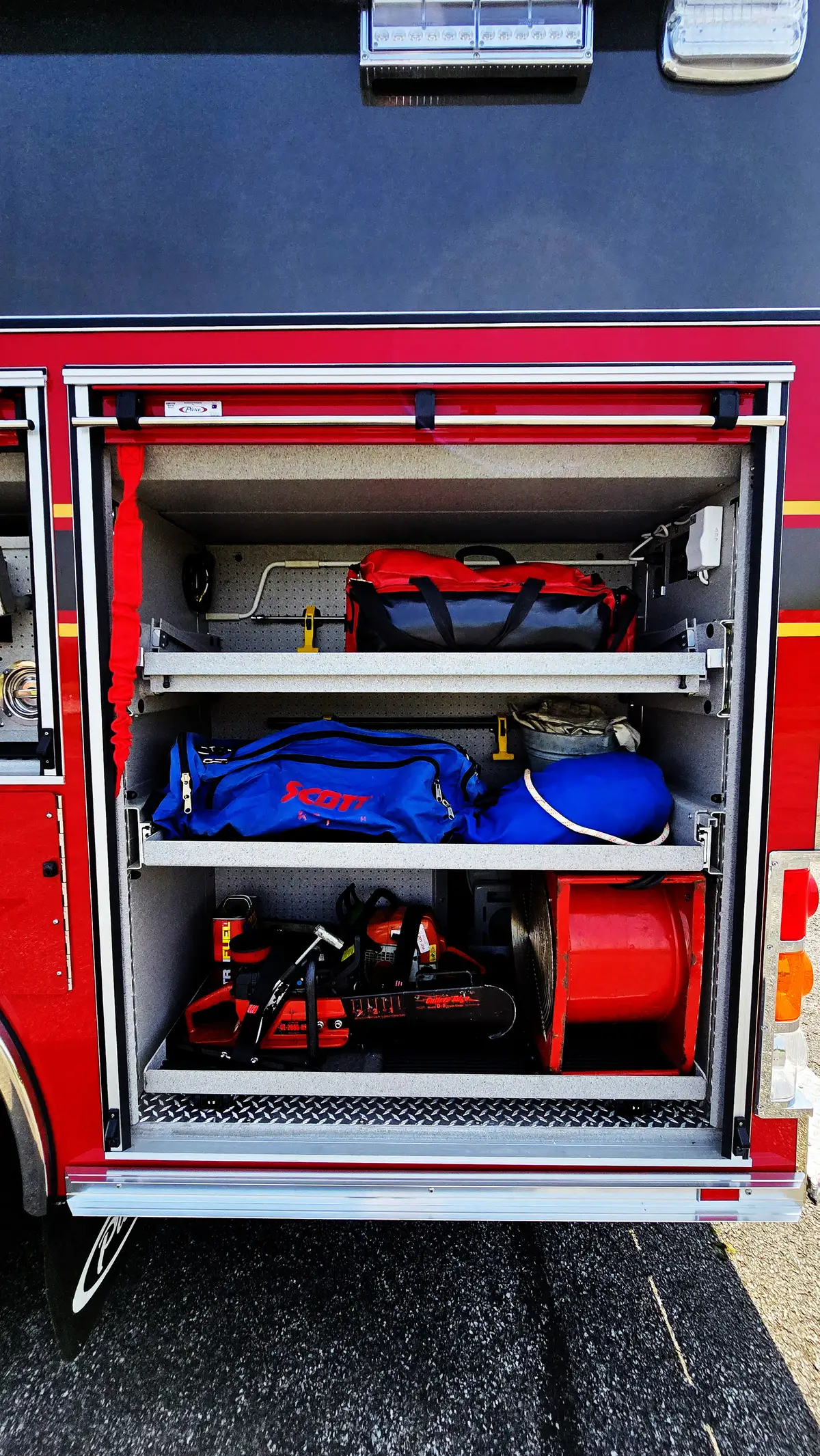 Open side compartment showing lower tray with rescue gear