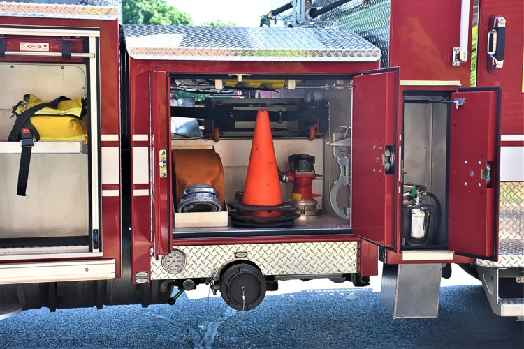 Open side compartment showing traffic cones and utility storage