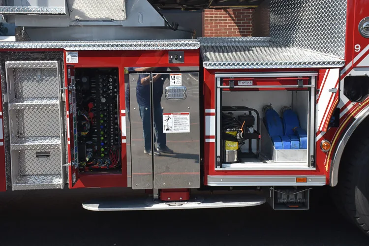 Driver-side profile with open side body panel showing equipment bay