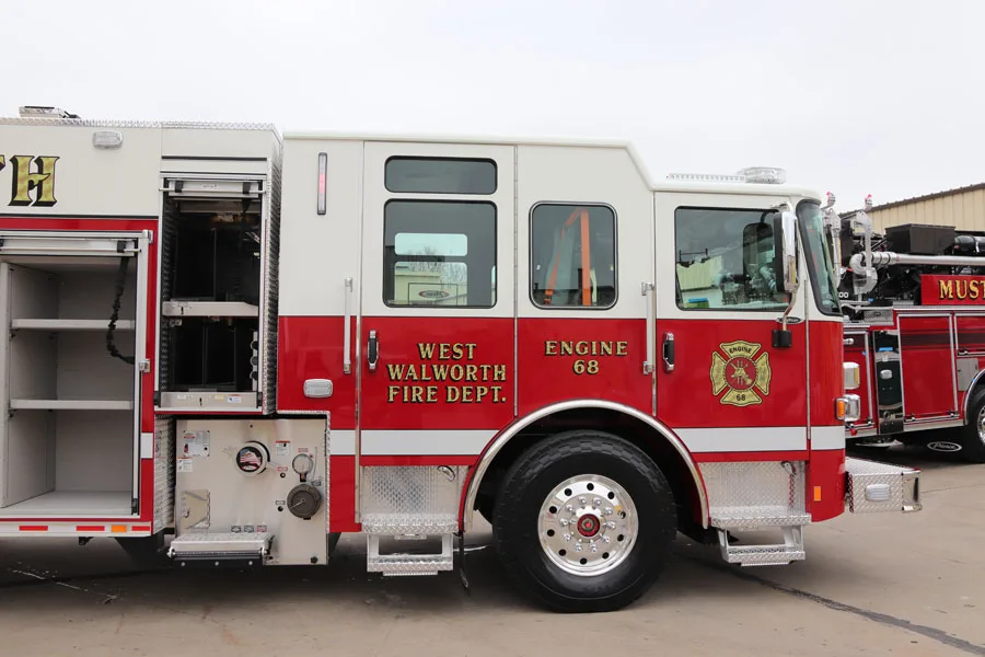 Driver-side profile with compartment doors open showing equipment storage