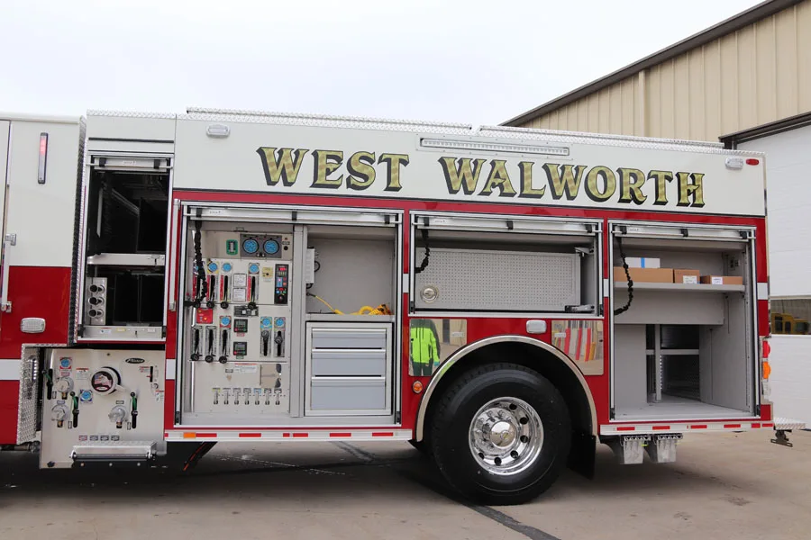 Driver-side mid-body view showing pump panel gauges and open compartments