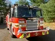 Wide front left view of the parked pumper showing bumper, cab, and side body profile.