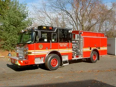 Front left exterior view showing cab, side pump panel, and long rear body compartments.