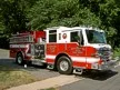Pumper front-left exterior view showing enclosed cab and side compartments