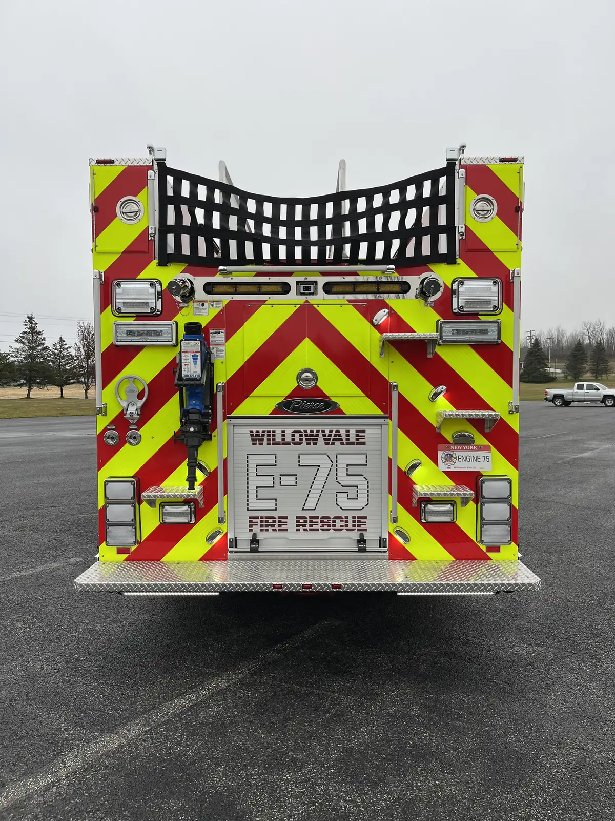 Rear view showing chevron striping, rear warning lights, and hosebed netting