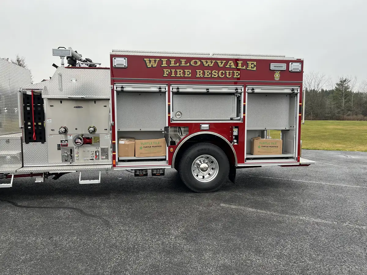 Driver-side rear body view showing compartment doors and wheel area