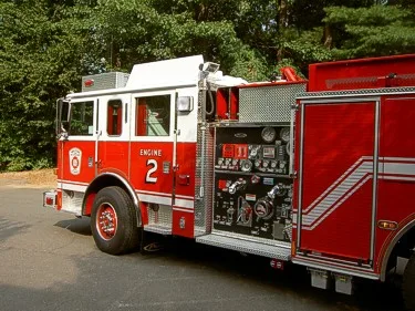 Driver-side profile view showing exposed pump panel, controls, and wheel area