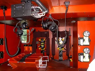 Equipment compartment close-up showing mounted tools, valves, and control hardware