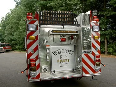Rear view showing chevron striping, rear door, and upper ladder rack