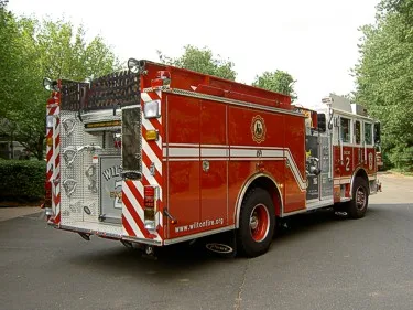 Rear-right exterior view showing rear body, chevrons, and side compartments