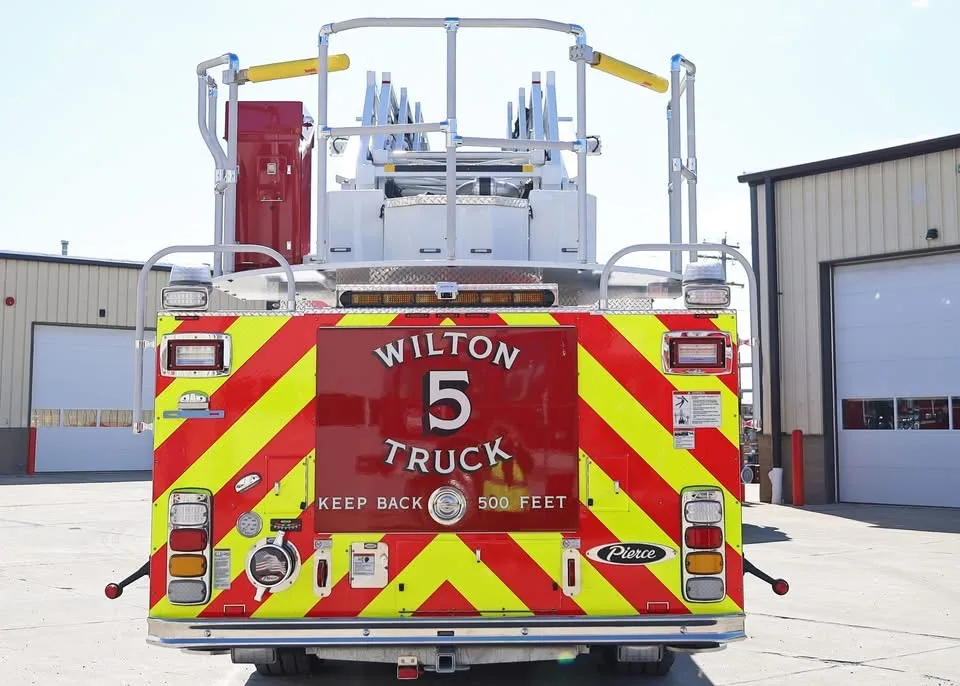 Rear view showing red-and-yellow chevrons and bucket platform at ladder tip