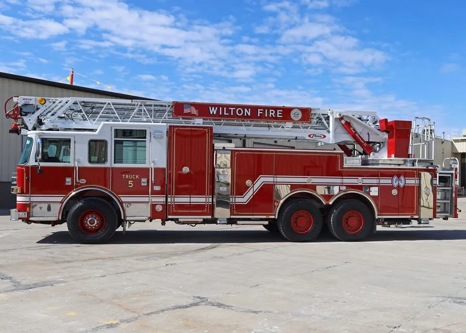 Driver-side full profile view showing ladder bed and side compartments