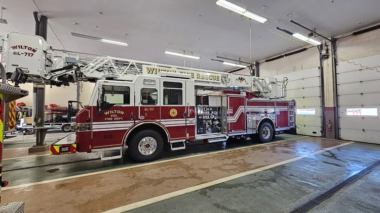 Wide bay view showing tower ladder side profile in apparatus room