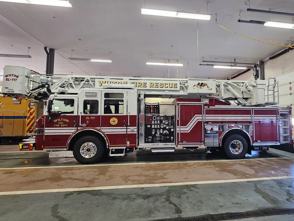 Driver-side full profile view showing ladder bed and tandem axle layout