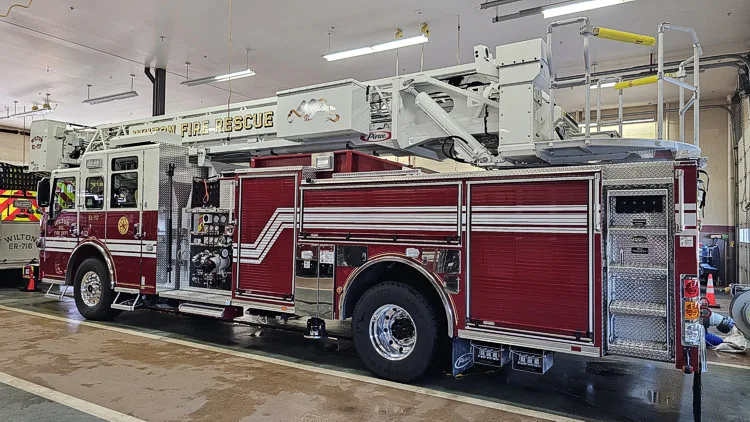 Driver-side profile showing tower ladder body and side compartments