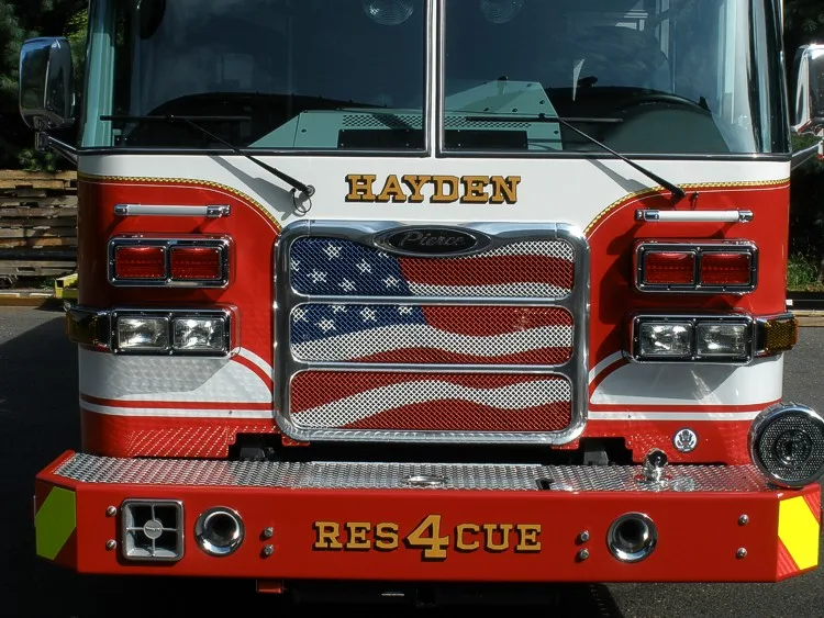 Head-on front close-up showing grille, windshield, warning lights, and front bumper inlets.
