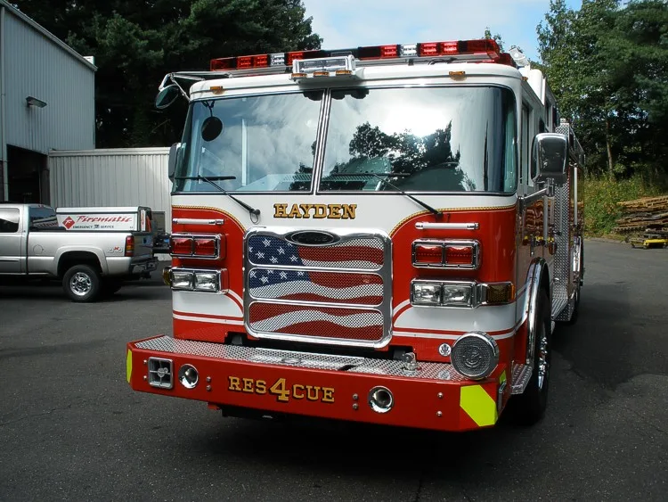 Front-right view highlighting the cab face, grille, warning lights, and bumper details.