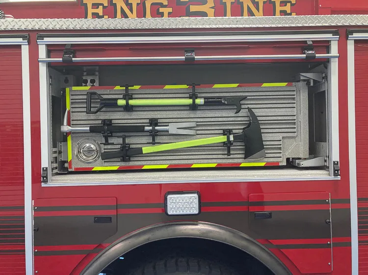 Open side compartment showing mounted long tools in rack