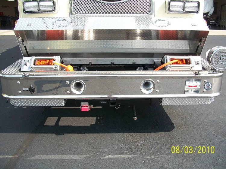 Front bumper tray close-up showing deployed slide-out storage with mounted tools and fittings.