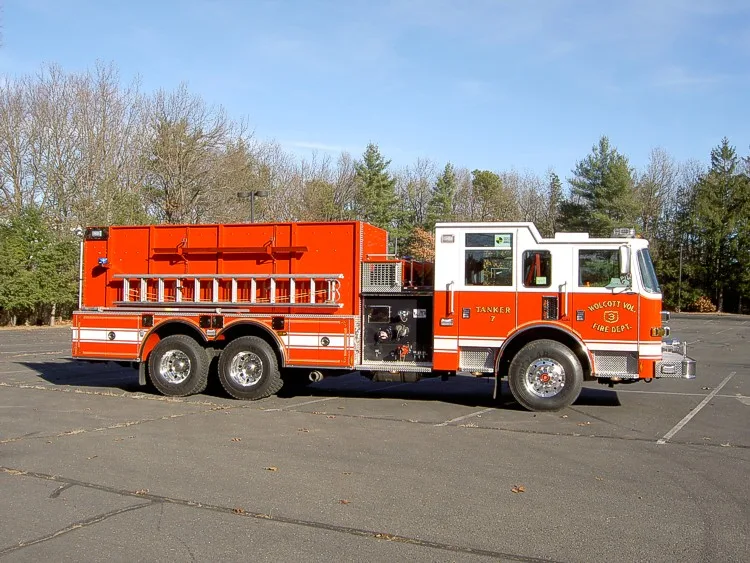 Officer-side profile showing tanker body compartments, pump panel section, and tandem rear wheel area.