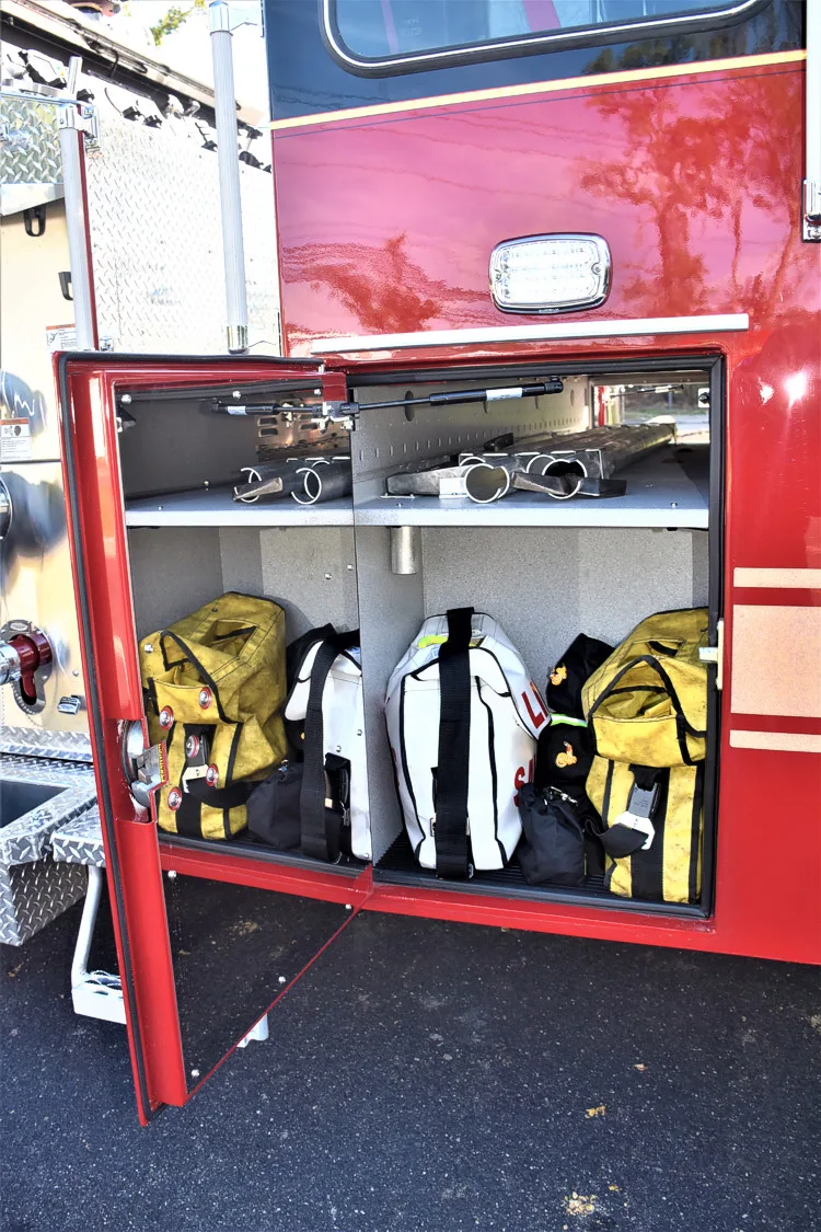 Open side compartment showing rescue tools and storage bins