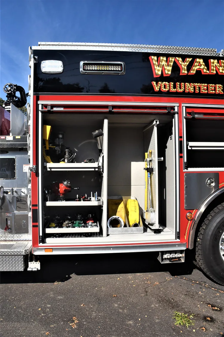 Open side compartment showing lower bay tools and mounted extinguishers