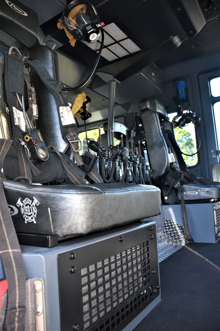 Cab interior view showing control panel, seats, and overhead console