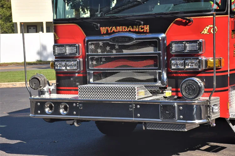 Front bumper close-up showing intake cap, grille bars, and warning lights
