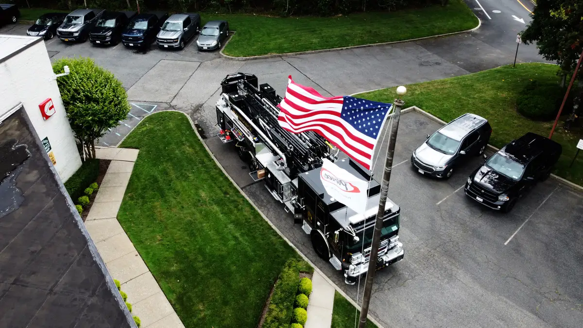 Aerial top-down front-left view showing cab roof, ladder bed, and side compartments