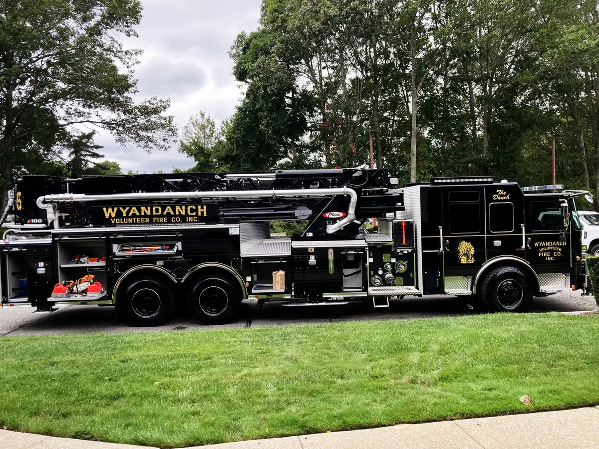 Rear-side compartment open showing mounted tools and storage bay