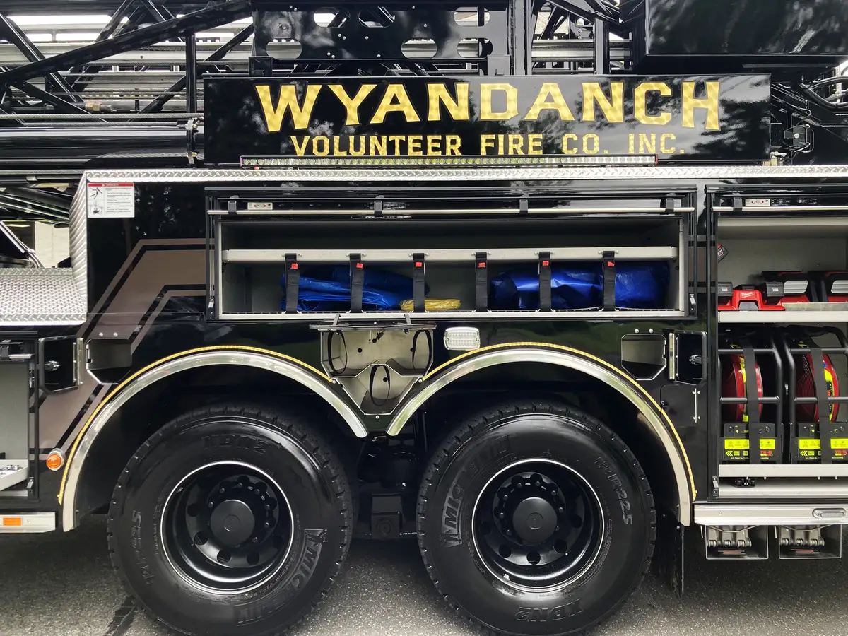Front grille badge close-up showing circular emblem on mesh grille