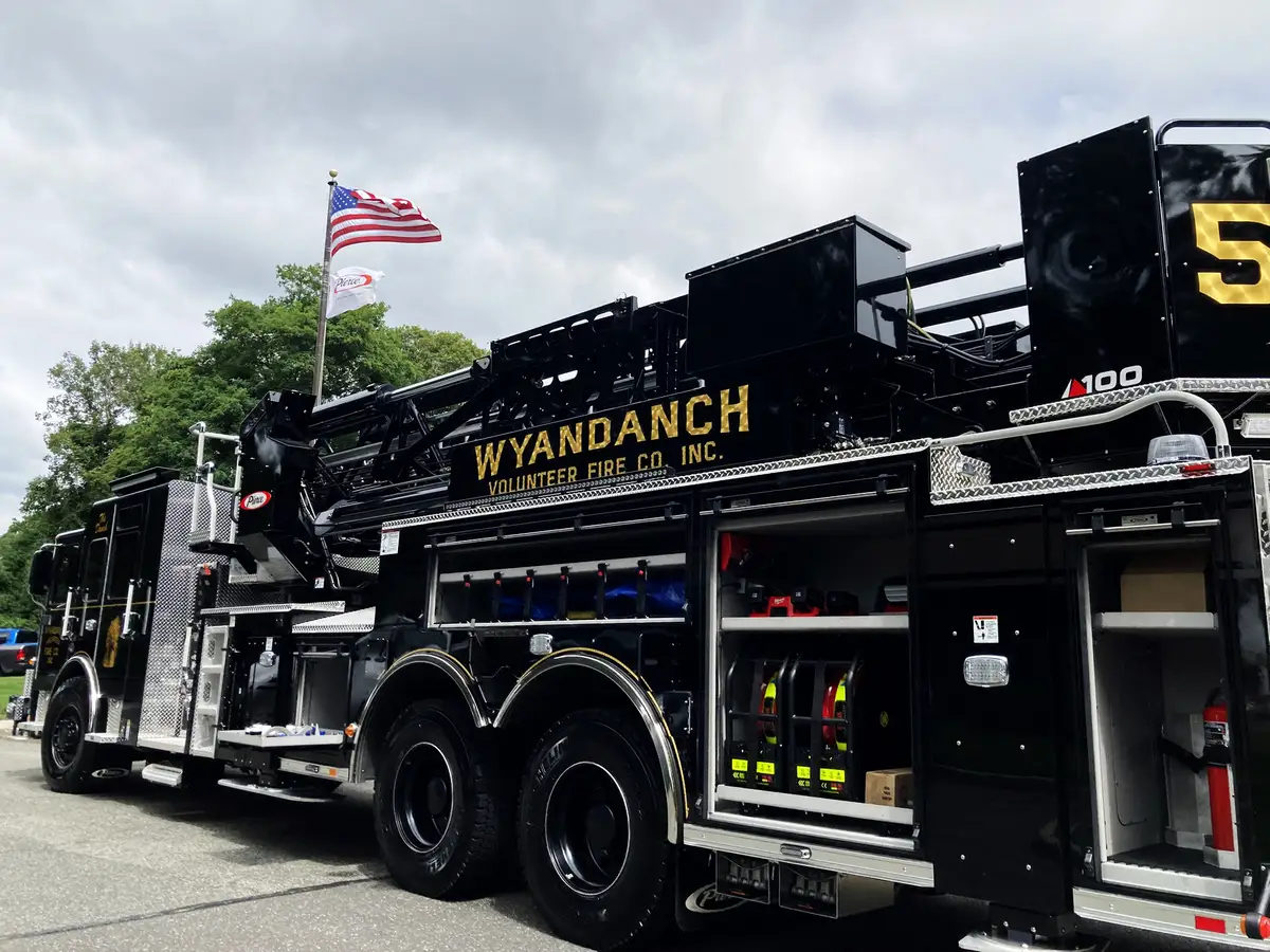 Driver-side profile view showing full body, ladder bed, and tandem wheels