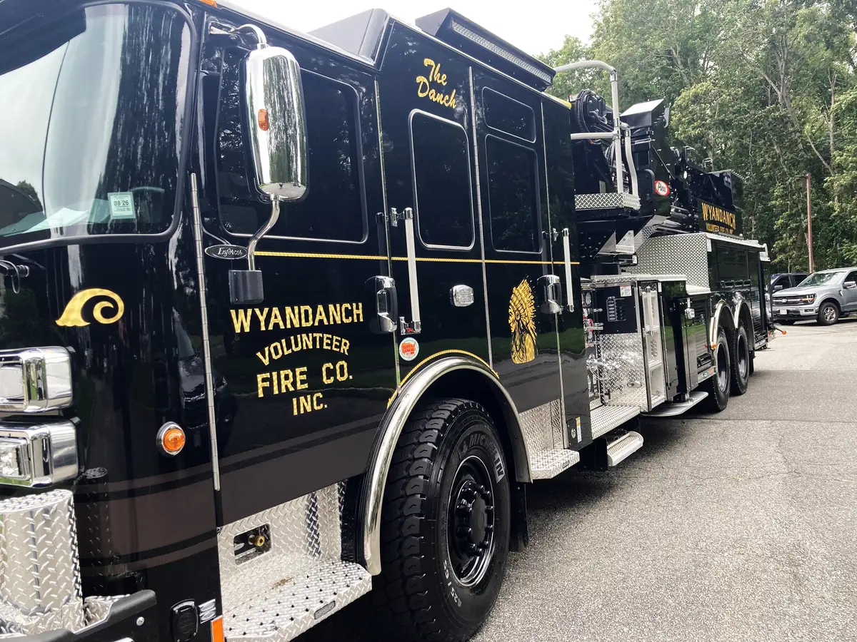 Driver-side profile view showing side compartments and tandem rear wheels