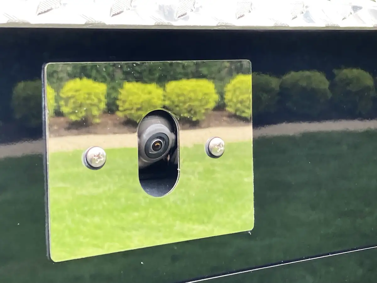 Front grille close-up showing chrome bars and hood lettering
