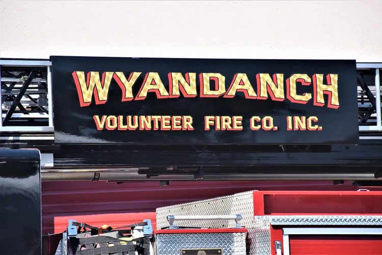 Body side lettering close-up on black panel above side compartments