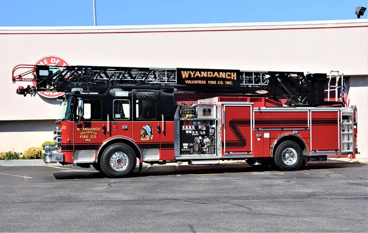 Driver-side profile view showing ladder truck body and tandem rear wheels