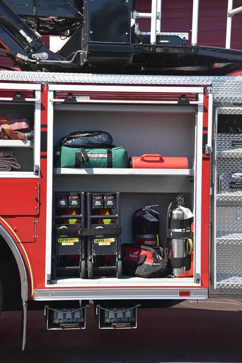 Open side compartment showing hand tools and equipment bins