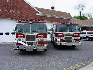 Head-on lineup view showing the front grilles, bumpers, and windshields of two pumpers.