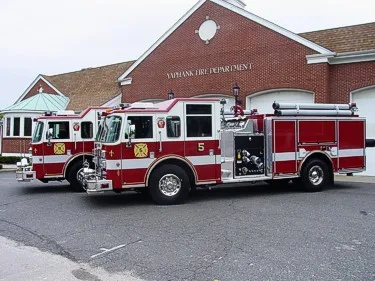 Side lineup view of two pumpers showing side pump panel areas and body compartments.