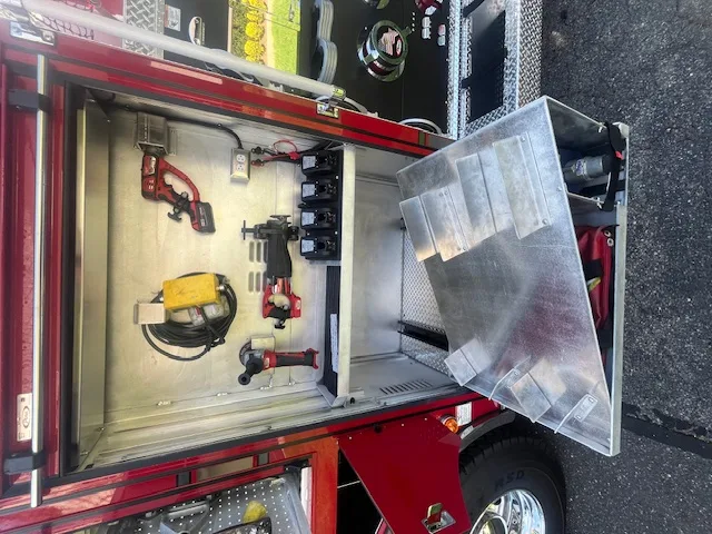 Open side compartment above rear wheel with slide-out tray and equipment storage